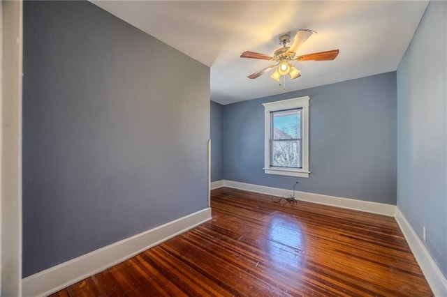 spare room featuring baseboards, wood-type flooring, and ceiling fan