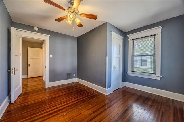 spare room with hardwood / wood-style floors, baseboards, visible vents, and ceiling fan