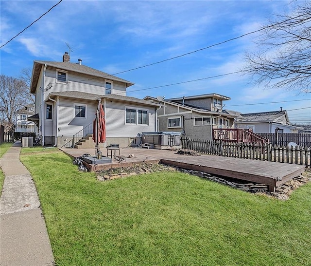 rear view of property featuring a lawn, a chimney, and fence