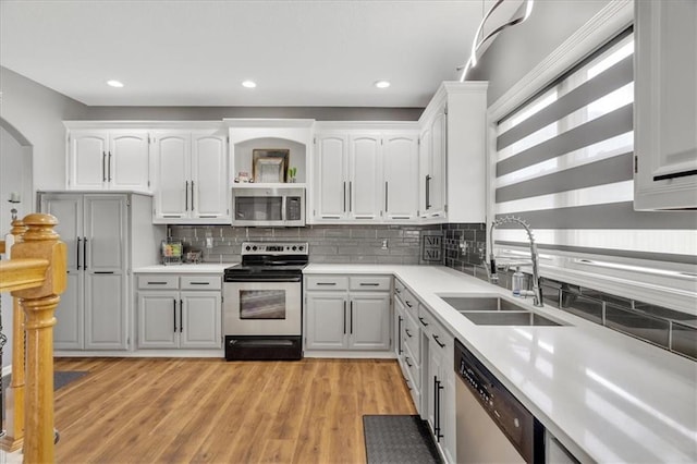11705 E 86th Ter, Raytown, MO 64138 - kitchen with stainless steel appliances, a sink, light countertops, backsplash, and recessed lighting
