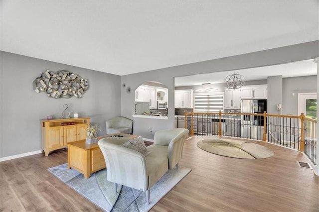 11705 E 86th Ter, Raytown, MO 64138 - living room featuring light wood finished floors, baseboards, and arched walkways