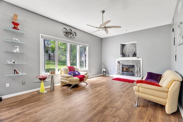 11705 E 86th Ter, Raytown, MO 64138 - living area with a ceiling fan, wood finished floors, a glass covered fireplace, and baseboards