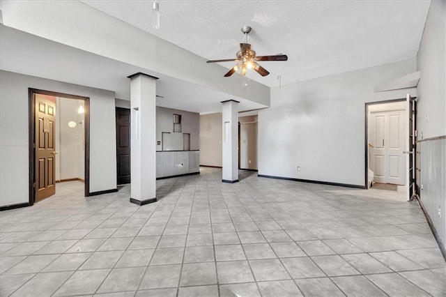11705 E 86th Ter, Raytown, MO 64138 - unfurnished living room with a ceiling fan, baseboards, light tile patterned floors, and a textured ceiling