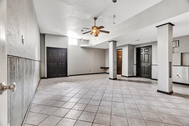 11705 E 86th Ter, Raytown, MO 64138 - unfurnished living room with a ceiling fan, tile patterned floors, a textured wall, and a textured ceiling