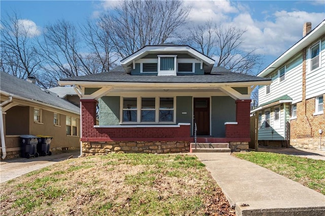 bungalow-style home featuring a porch and brick siding