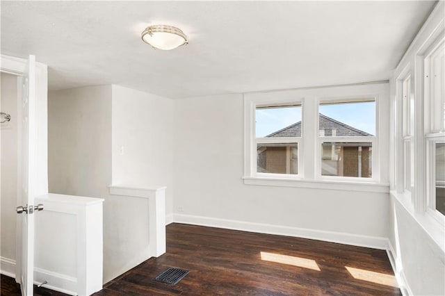 empty room featuring visible vents, baseboards, and wood finished floors