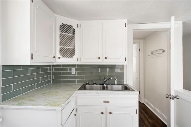 kitchen featuring a sink, tasteful backsplash, and white cabinetry