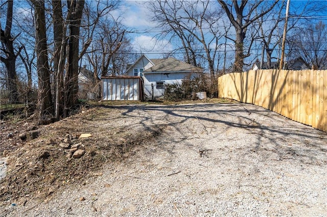 exterior space featuring an outbuilding, a shed, and fence