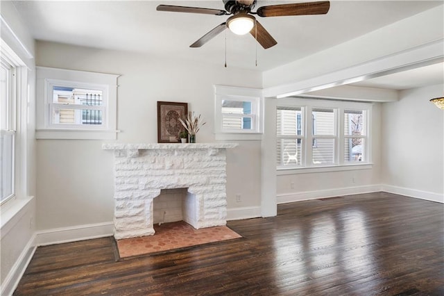 unfurnished living room featuring plenty of natural light, a fireplace, baseboards, and wood finished floors