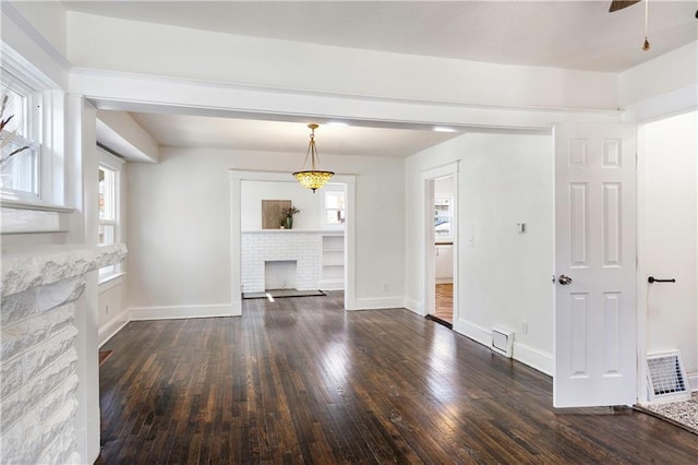 unfurnished living room with visible vents, a brick fireplace, baseboards, and hardwood / wood-style floors