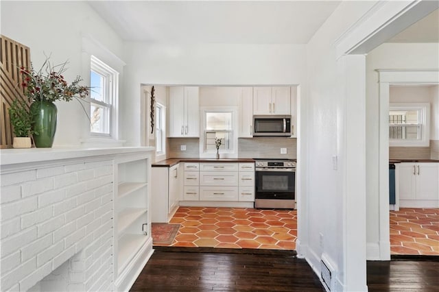 kitchen with dark wood-style floors, open shelves, stainless steel appliances, white cabinetry, and backsplash