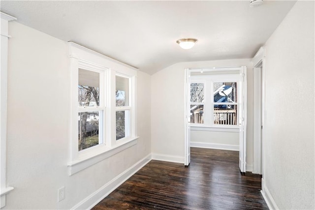 interior space featuring a wealth of natural light, baseboards, lofted ceiling, and wood finished floors