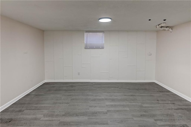 spare room with dark wood-type flooring and baseboards