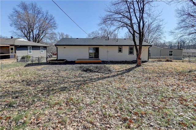 rear view of property with a deck and fence