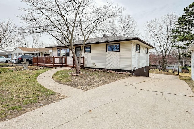 ranch-style house with concrete driveway and a wooden deck