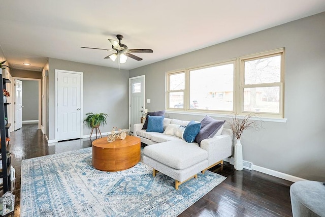 living area with dark wood finished floors, baseboards, and ceiling fan