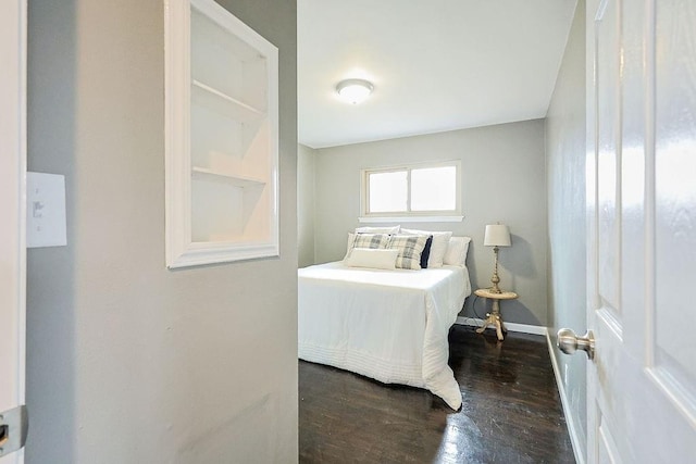 bedroom with baseboards and wood finished floors