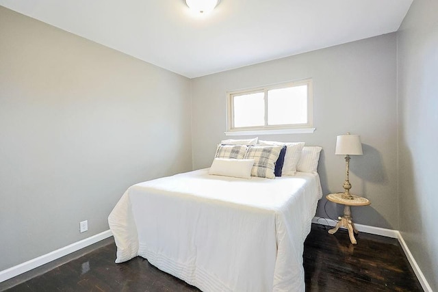 bedroom featuring baseboards and dark wood finished floors