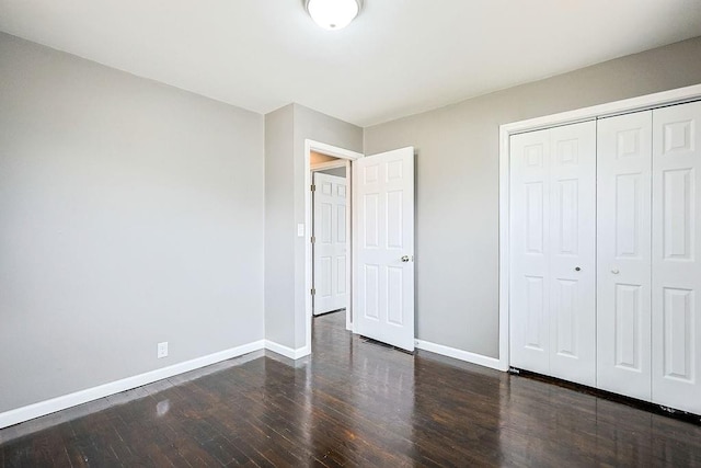 unfurnished bedroom featuring a closet, baseboards, and wood-type flooring