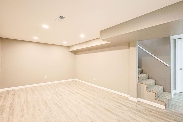 finished basement with stairway, wood finished floors, visible vents, baseboards, and recessed lighting