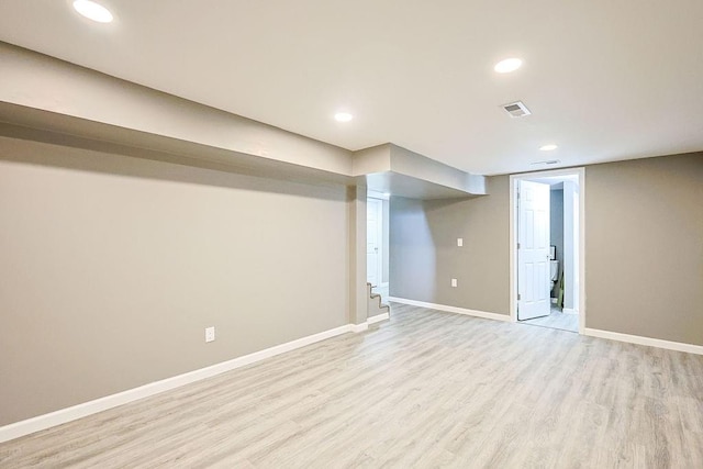 finished below grade area with visible vents, recessed lighting, baseboards, and light wood-style floors