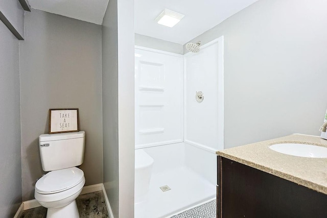 bathroom featuring baseboards, toilet, a stall shower, and vanity