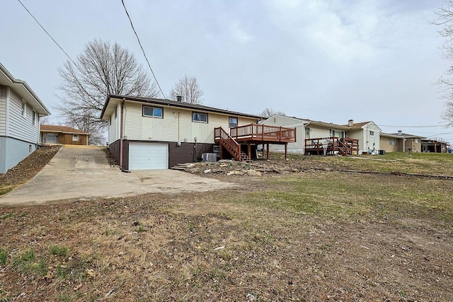 back of property with stairway, cooling unit, a garage, and a wooden deck