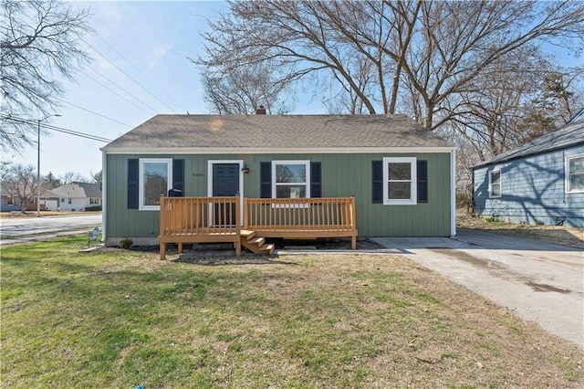 view of front of house with a front lawn and roof with shingles