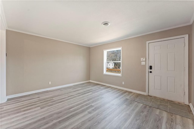 entryway with visible vents, light wood-style floors, baseboards, and ornamental molding