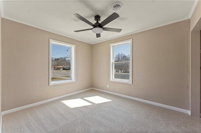 spare room featuring carpet flooring, a ceiling fan, baseboards, and ornamental molding