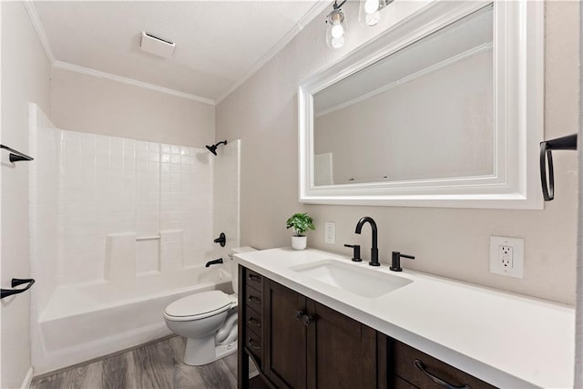 bathroom featuring toilet, ornamental molding, wood finished floors, shower / bathing tub combination, and vanity