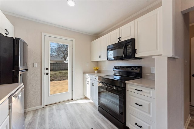 kitchen with light wood-style floors, black appliances, ornamental molding, and light countertops