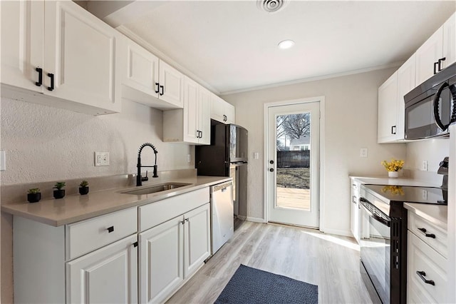 kitchen featuring white cabinetry, black appliances, crown molding, and a sink