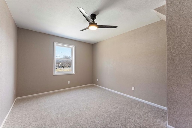 unfurnished room with baseboards, ceiling fan, and carpet floors