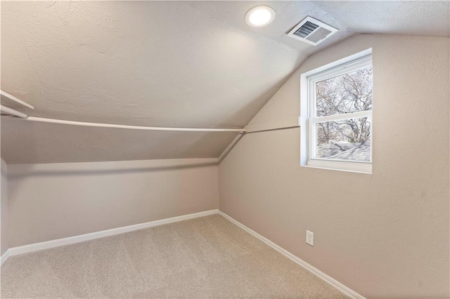 bonus room with visible vents, lofted ceiling, a textured ceiling, carpet flooring, and baseboards