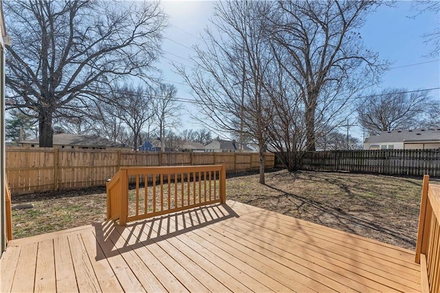 wooden terrace with a fenced backyard