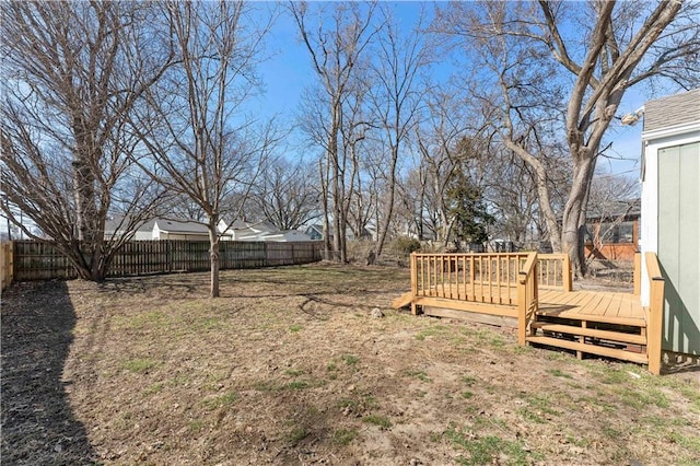 view of yard with a wooden deck and a fenced backyard