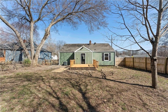 back of property featuring a fenced backyard, central AC, a chimney, and a deck