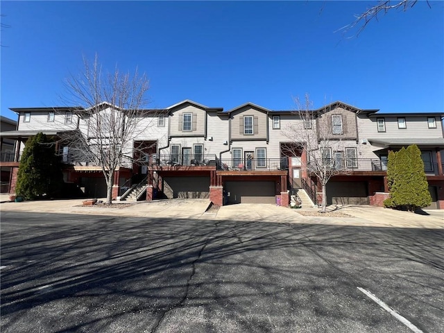 view of front of house featuring concrete driveway, stairs, and a garage