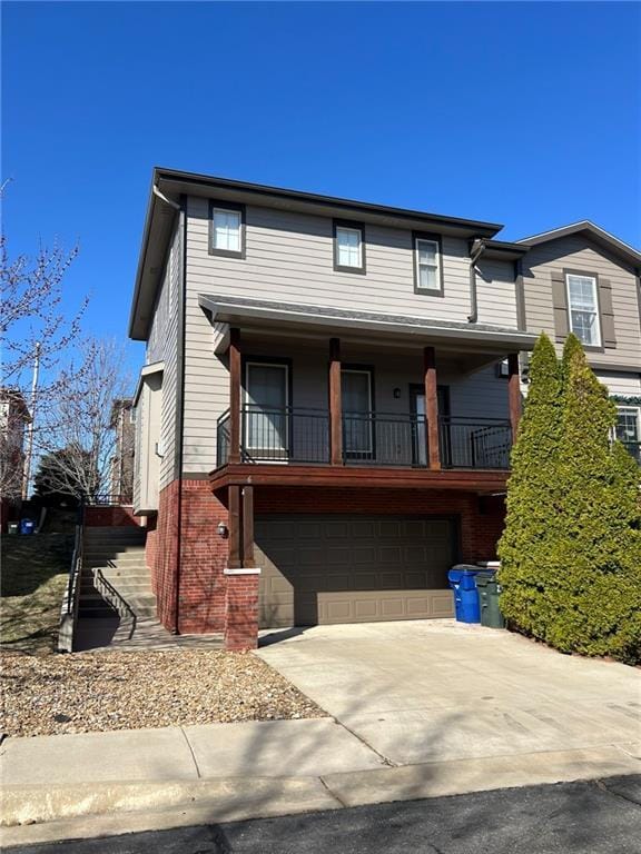 view of front of house with a garage, brick siding, concrete driveway, and stairs