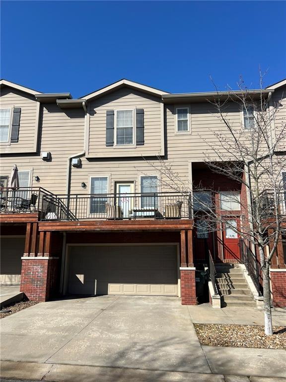 multi unit property featuring an attached garage and driveway