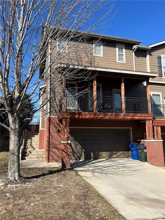 multi unit property featuring concrete driveway and an attached garage