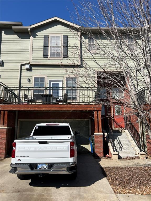 multi unit property featuring aphalt driveway and an attached garage