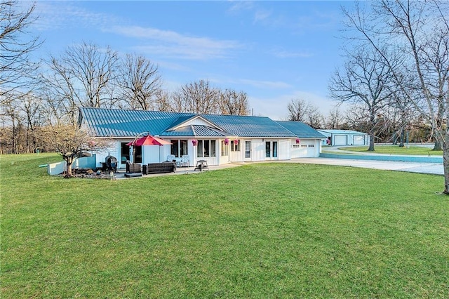 view of front of house with a front yard, driveway, a garage, outdoor lounge area, and metal roof