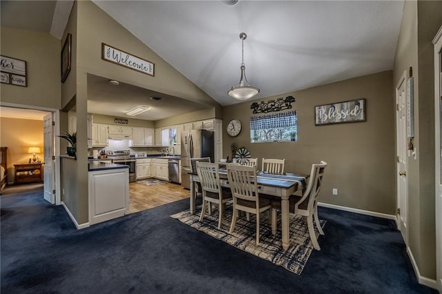 dining space with baseboards, carpet flooring, and vaulted ceiling