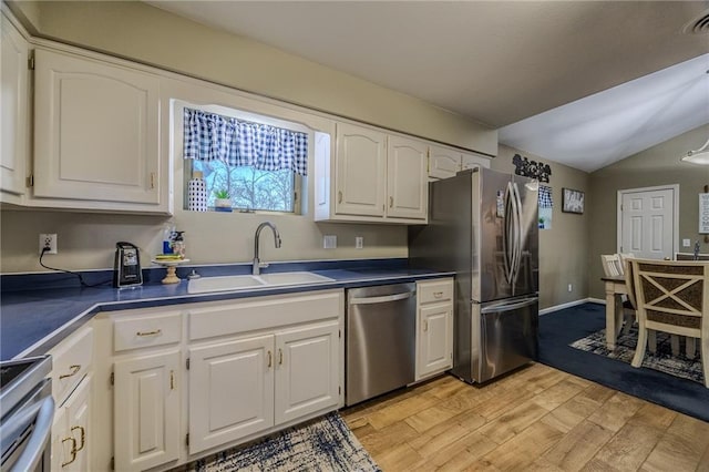 kitchen featuring a sink, dark countertops, white cabinets, and stainless steel appliances