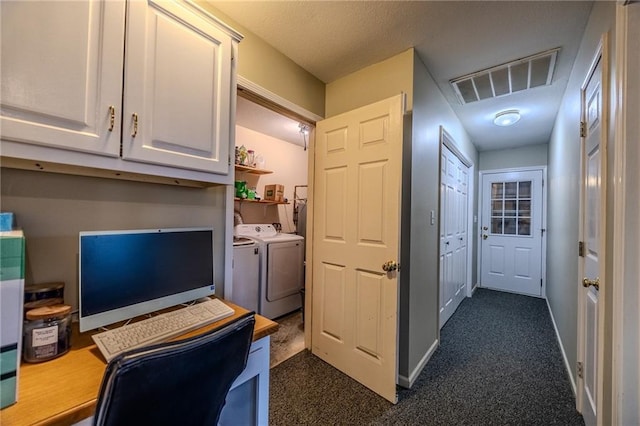 office featuring washing machine and dryer, visible vents, dark colored carpet, and baseboards