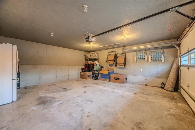 garage featuring a garage door opener and freestanding refrigerator