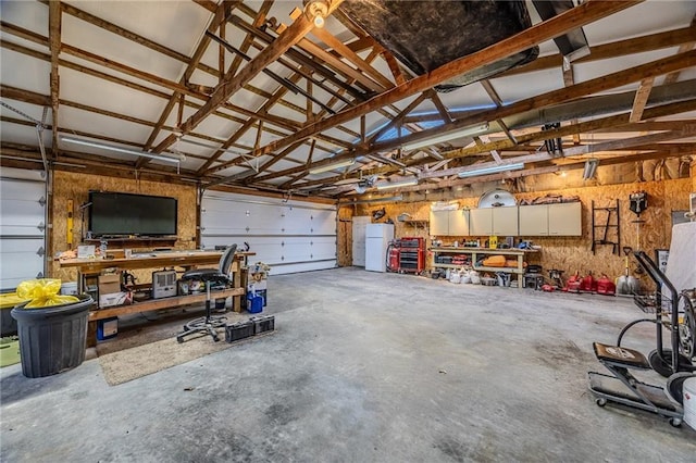 garage featuring a workshop area and freestanding refrigerator