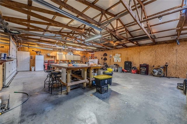 garage featuring a workshop area and freestanding refrigerator